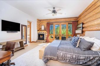 Bedroom at Villas at Tristant 225 featuring a log wall and fireplace.