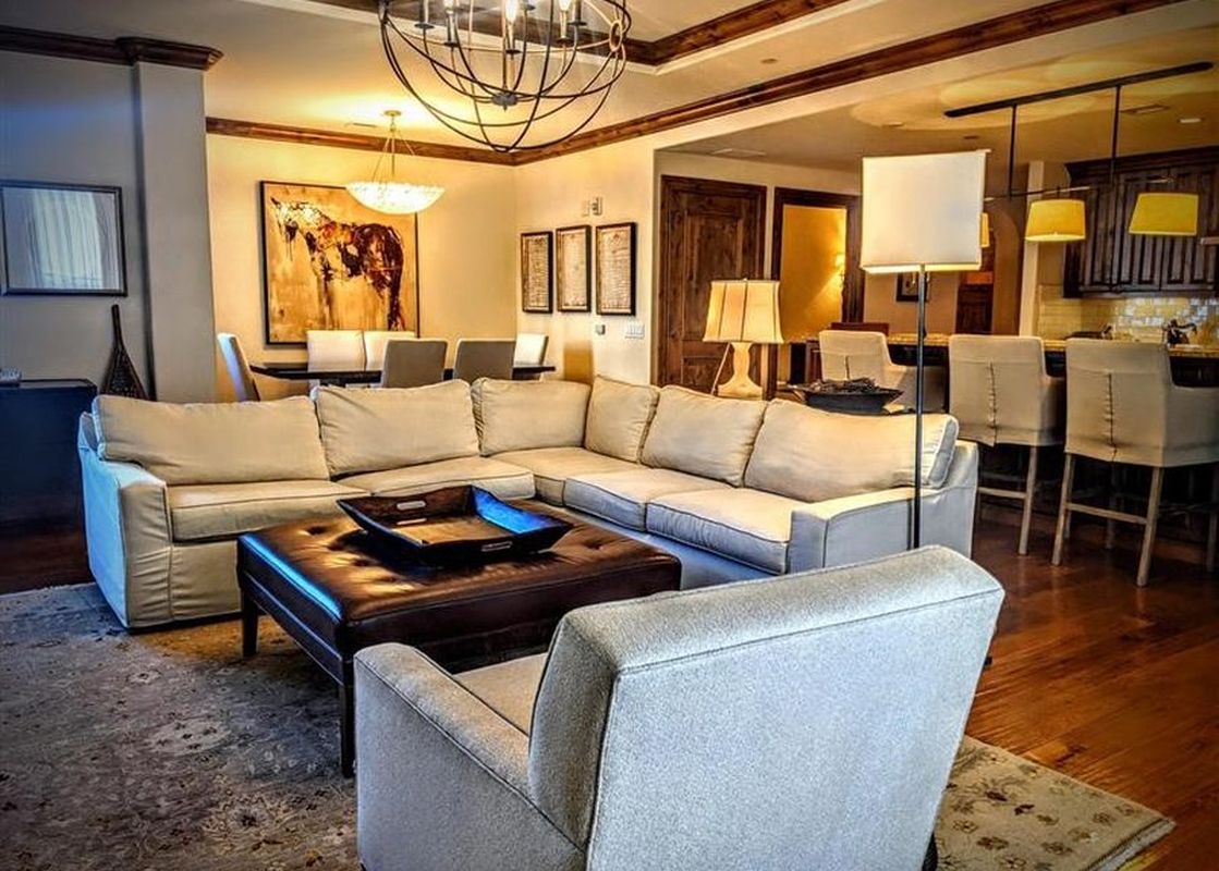 A spacious, open-concept living and dining area in the Arrabelle 1 Bedroom with warm lighting and elegant furnishings.