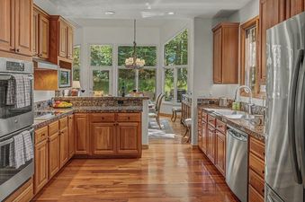 A modern kitchen with wood cabinets, granite countertops, and stainless steel appliances at Wild Iris Lodge.