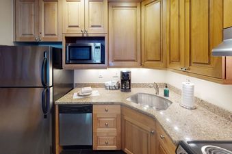 Manor Vail 173 kitchen features stainless steel appliances, light wood cabinets, and granite countertops.