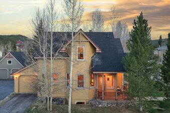 The French Street Retreat stands brightly under a dramatic sky, featuring a blend of classic and rustic architectural elements.