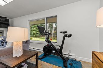 A stationary Peloton bike setup next to a large window in Alpine Retreat Jackson Hole.