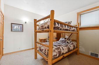 The cozy children's bunk beds in Cottonwood 204, adorned with rustic, nature-themed bedding.