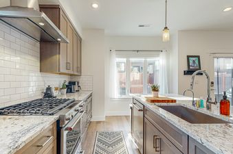 The kitchen of Sandlewood Sanctuary has a stainless steel stove and oven, white subway tile backsplash, and granite countertops.