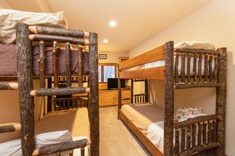 A cozy bunk room in Fairview Lodge featuring two sets of rustic wooden bunk beds, creating a comfortable and practical sleeping arrangement for guests.