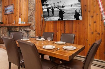 The dining area at Beaver Village 2032 2B 2B features a rustic wooden table set for six.