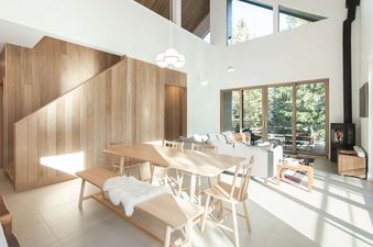 Bright open-concept dining and living area at Serenity Domain with natural wood accents and large windows.