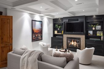 A cozy, well-lit living area featuring comfortable seating, a fireplace, and a television setup.