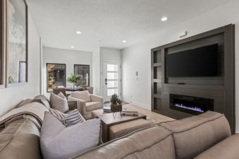 A modern living room with a sectional sofa, a coffee table, and a fireplace.