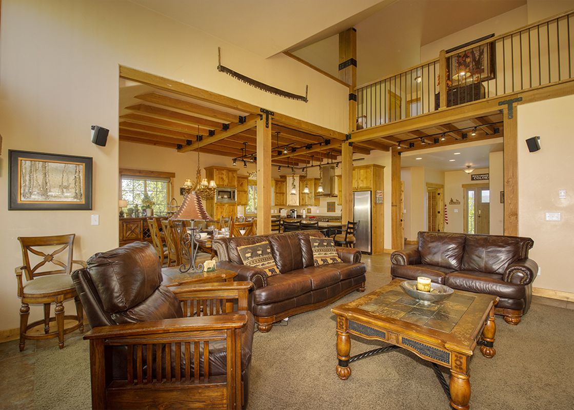 The living area of the Leland Creek Home boasts comfortable leather seating and a cozy atmosphere.