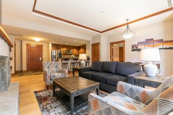 A living room with a couch, two chairs, a coffee table, and a fireplace.
