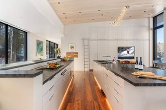 The sleek modern kitchen at The Dragonfly Lodge featuring dual islands and snowy winter views.