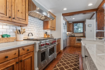 The kitchen of Grand Lodge Four Bedroom 306, featuring stainless steel appliances, a double oven, and a white marble countertop.