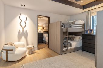 A cozy bedroom at Lone Star Lodge Mountain Village with a unique animal skull decor piece and bunk beds.