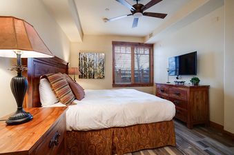The bedroom in Emerald Lodge EL5111 features a wooden dresser and a large bed.