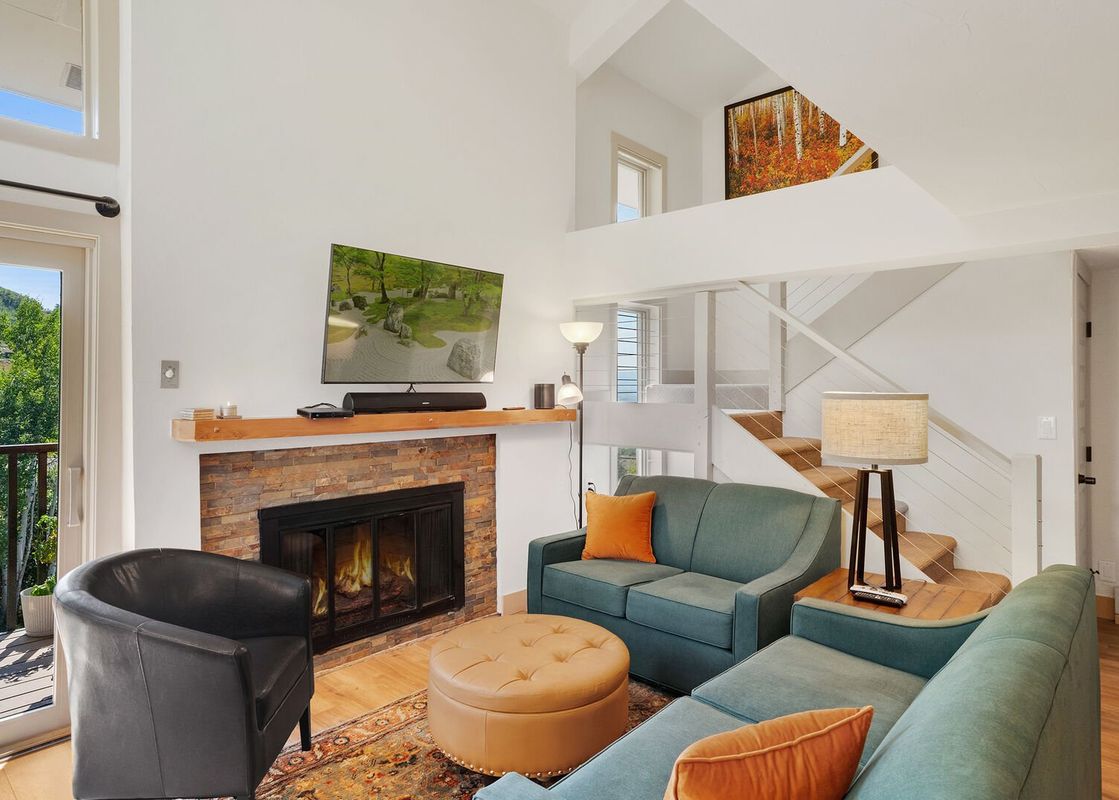 A living room with a fireplace and a view of the mountains.