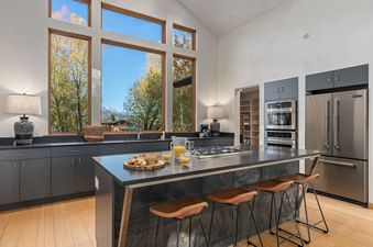 Modern kitchen with large windows showcasing mountain views.