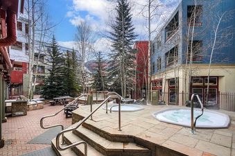 The image shows the courtyard area with hot tubs at Silver Mill 2BR.