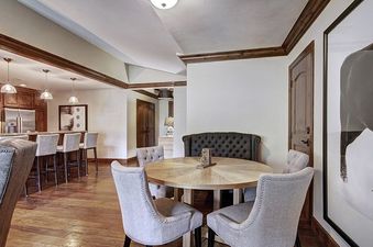 The dining table and chairs in the Ritz Carlton 2BR Valley View condo, with the kitchen in the background.