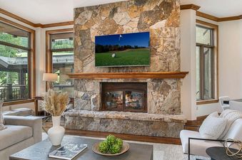 Centennial Vista features a large stone fireplace in the living area with a flat screen TV above the mantle.