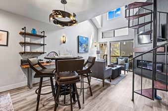 Open-concept dining and living space in Snowcrest 302 with a spiral staircase.