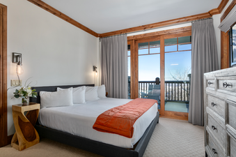 The master bedroom in Grand Lodge Three Bedroom 301 has a king-size bed, a bedside table, and a dresser with drawers.