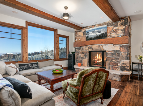 Grand Lodge Three Bedroom 301 living room with a fireplace, a large sectional sofa, a coffee table, and a window with a view of the mountains.