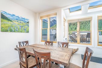 Dining area in Willow 302 featuring a rustic wooden table and views of the surrounding mountains.