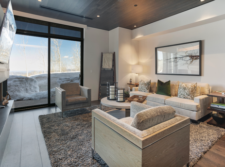 Living room with a large window overlooking a snow covered landscape.