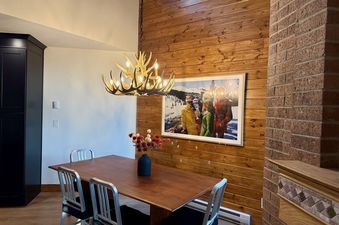 Dining table and chairs under an antler chandelier at the Lodge at Steamboat F303.