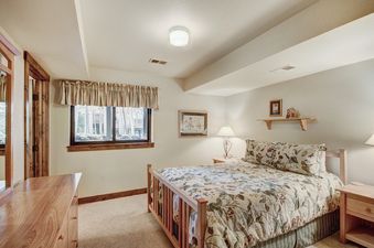 A bedroom with a bed, a window, and a nightstand.