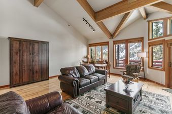 Enclave 11's living area features vaulted ceilings with wooden beams and comfortable seating.