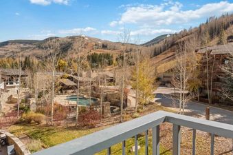 A captivating autumn mountain landscape, showcasing a resort with a pool and hot tub, all viewed from the private balcony of the Lodge Tower 387 3BR.