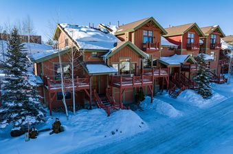 Exterior view of the Hygge Hideaway townhome in winter under a clear blue sky.