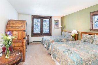Cozy bedroom at Manitou Lodge 3 featuring two beds and a view of the snowy outdoors.