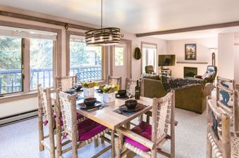 The dining and living area inside Rendezvous A4 featuring a rustic dining set and comfortable living room seating.