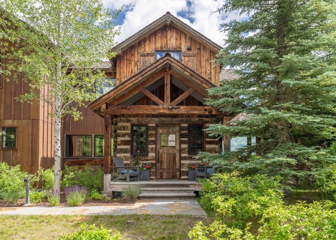 The charming log and timber entrance of Shooting Star Cabin 05 in summer.