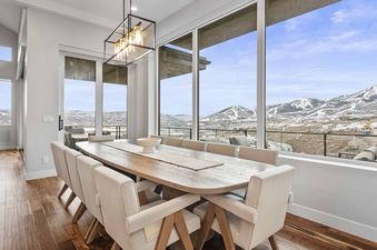 Dining area with a large wooden table and surrounding windows looking out at mountain views at SkyRidge 1307.