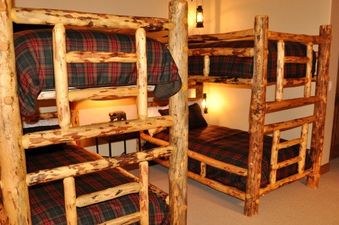 A cozy bedroom in Villas At Tristant 110 features custom log bunk beds, perfect for family retreats.