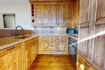 A kitchen with wood cabinets and granite countertops.