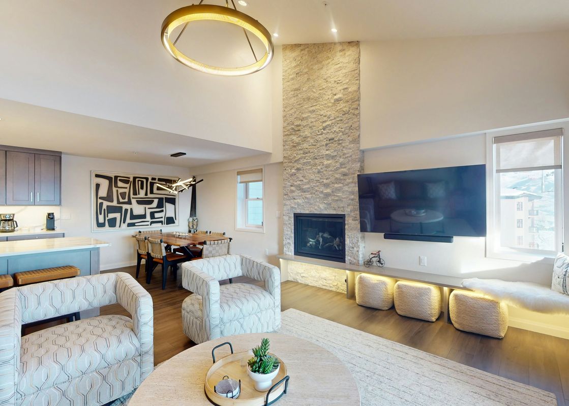 A modern and inviting living area in Torian Plum Plaza 804 with a stone fireplace, flat-screen TV, and an open-concept design.