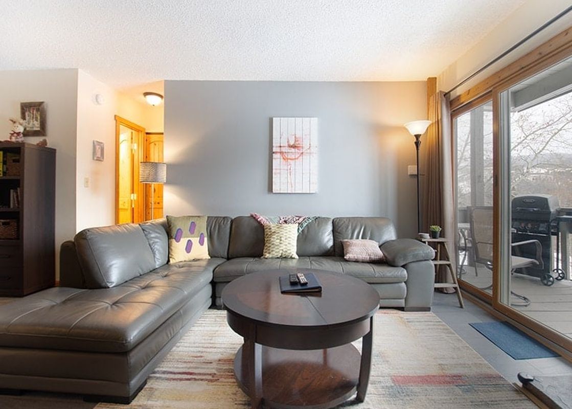 A cozy living room in Silverado I Building B Unit 204 features comfortable seating and a view of the outdoors.