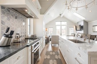 The modern kitchen of Snowflake Villa, featuring white cabinetry, marble countertops, stainless steel appliances, and an open-concept layout.