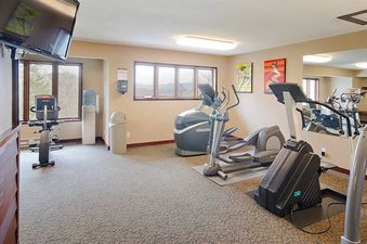 An upside-down gym with various exercise machines, windows, and artwork on the walls at the Ranch at Steamboat RA520.