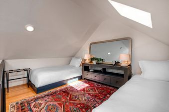 Bedroom with twin beds and colorful rug at Alpine Minnies Old Town.