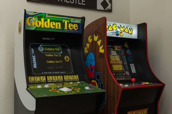 A close-up view of the two classic arcade machines in the games room at Apex Manor.