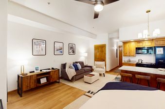 A bright and airy open-concept living room and kitchen area at EagleRidge Lodge 313 featuring modern rustic decor.