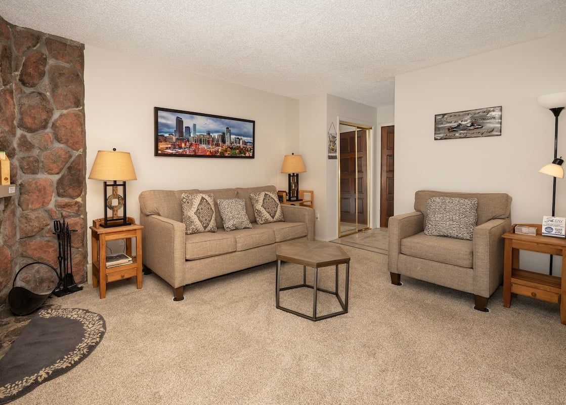 A cozy living room at Meadow Ridge Court 9 Unit 4 features comfortable seating and a stone fireplace.