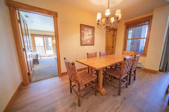 The dining area at Springs 8819 features a wooden table and seating for six.
