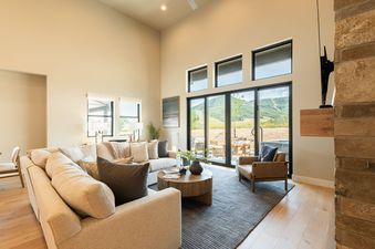 Bright living room at Mayflower Lakeside 9506 featuring a large sectional sofa and sliding glass doors showing mountain views.